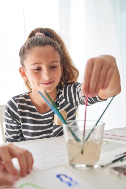 istock Content girl choosing paintbrush at table 2166135814