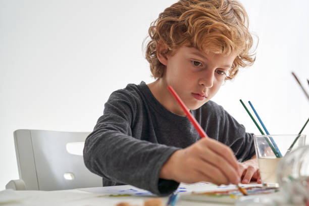 istock Cute boy painting with aquarelle 2166135889