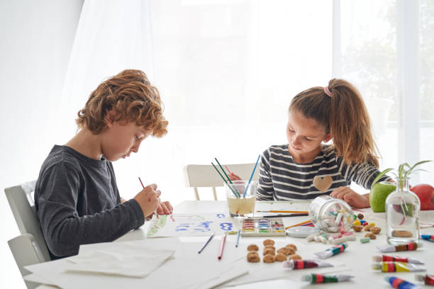 istock Brother and sister drawing sitting at table 2166135931