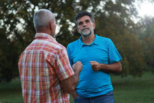 Two senior men speaking interview in public park