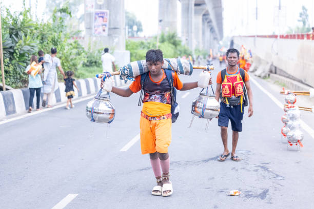 Ghaziabad, Uttar Pradesh, India - July 2024:  Portrait of hindu pilgrims performing kanwar yatra barefoot during swan shivratri and carrying holy ganga water to worship hindu god shiv with rituals.