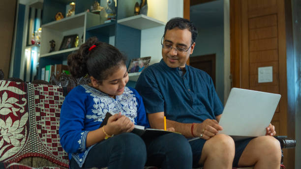 istock Man working and daughter studying on sofa at home 2166137527