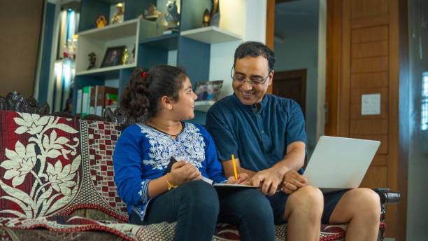 istock Man working and daughter studying on sofa at home 2166137537