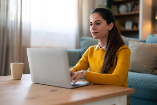 istock Smiling Woman Using Laptop at Home 2166139002