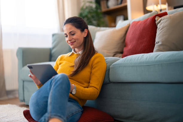istock Casual Home Setting with Smiling Woman Using Tablet 2166139011