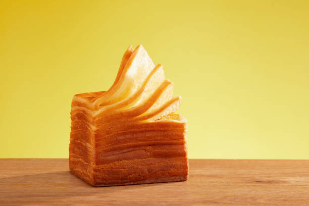 Thousand layer toast, sliced bread, photography close up, wooden table and golden background