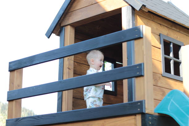 istock A small child smiles playfully while hiding in a children's playhouse 2166152608