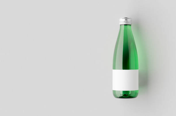 istock Small water bottle mockup with blank label. Green glass, copyspace. 2166154754