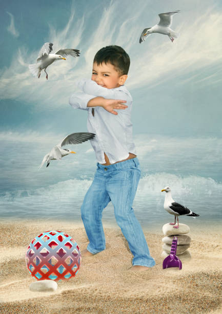 A little boy on the beach fights off attacking seagulls