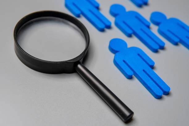 istock Close-up image of magnifying glass and figurines. 2166181754