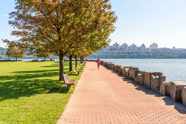 istock Woman running on a riverbank path on a sunny autumn day 2166181832