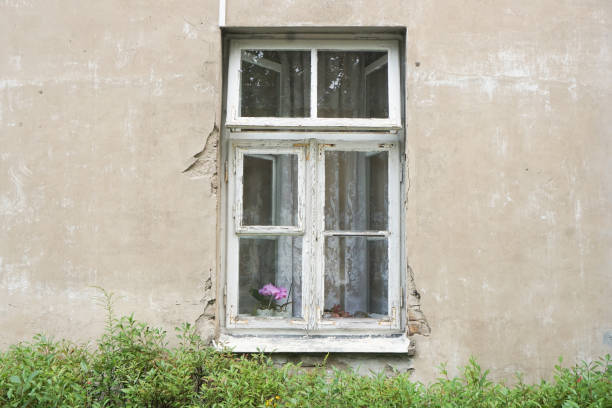 istock Grunge window background.Old scratched concrete building facade with a wooden windo frame in the center. 2166190747
