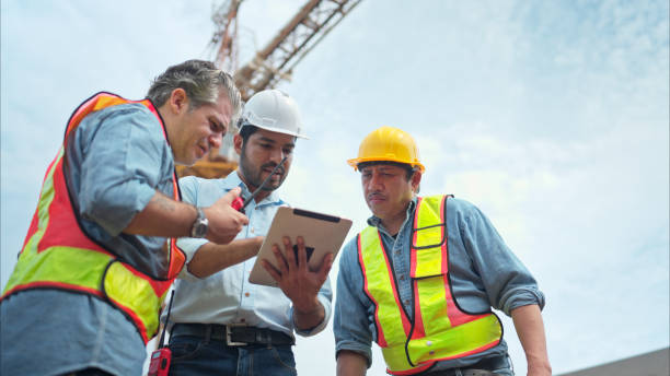 istock Group of workers at construction site are discussing construction progress with a tower crane in the background 2166193582