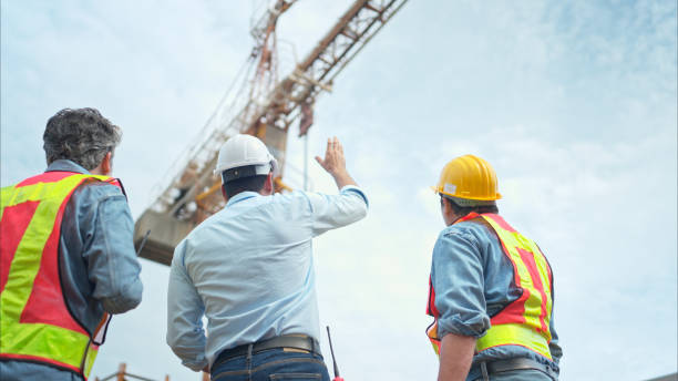 istock Group of workers at construction site are discussing construction progress with a tower crane in the background 2166193585