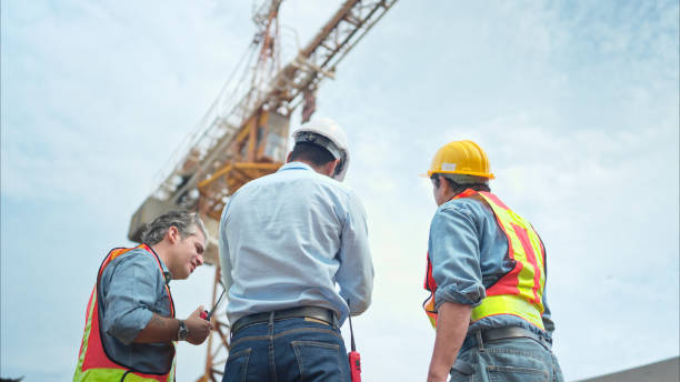 istock Group of workers at construction site are discussing construction progress with a tower crane in the background 2166193653