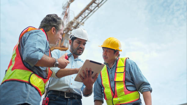istock Group of workers at construction site are discussing construction progress with a tower crane in the background 2166193899