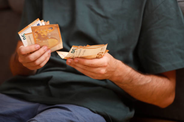young boy's hands counting 50 euro bills