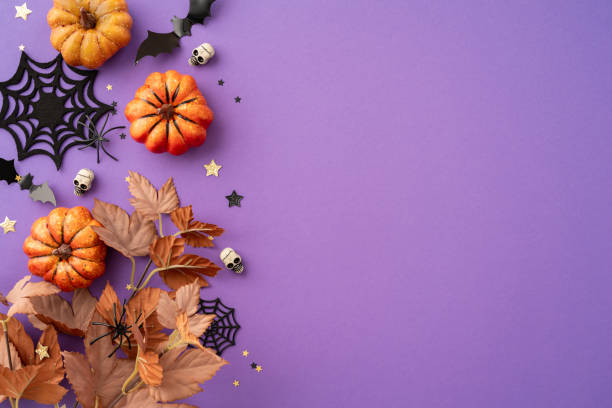 istock Decorative Halloween background featuring pumpkins, dried leaves, skulls, spider webs, and bat shapes on a purple backdrop 2166202854