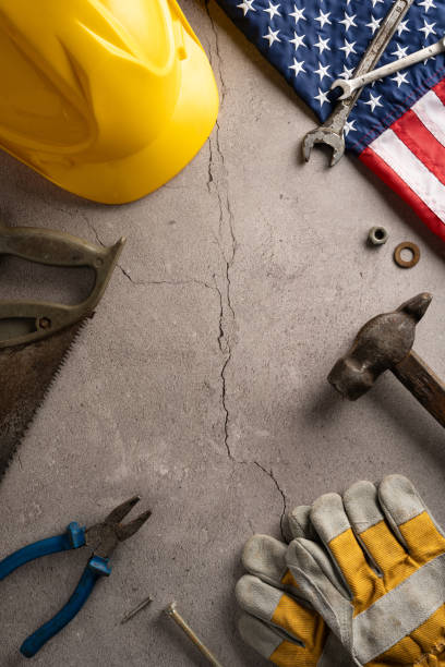 istock Labor Day vertical concept featuring various tools, a yellow hard hat, and an American flag, symbolizing the hard work and dedication of workers 2166202877