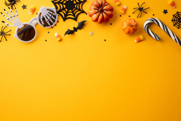 Festive Halloween holiday background featuring pumpkins, candy, and spooky decorations on a vibrant orange backdrop