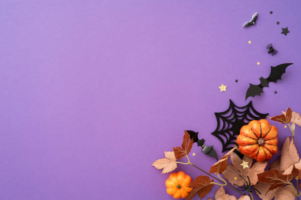 istock Halloween themed background featuring pumpkins, bats, and spider web decorations on a purple surface 2166202883