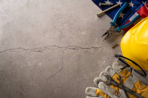 istock Top view of construction tools, hard hat, gloves, and American flag on a concrete surface, symbolizing Labor Day in the USA 2166202886
