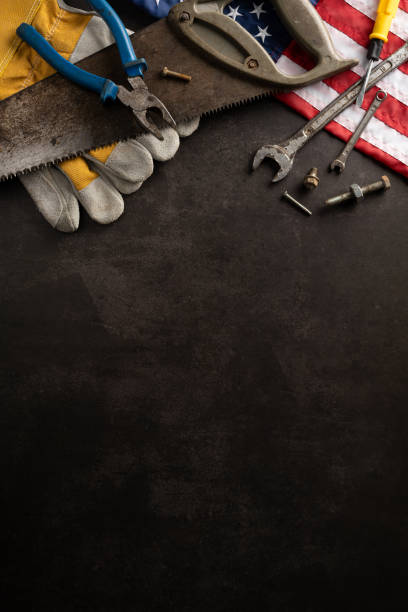 istock Top vertical view of various tools and USA flag on a dark background symbolizing Labor Day celebration 2166202889