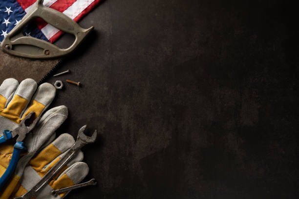 istock Flat lay of assorted tools with protective gloves and American flag on dark background, symbolizing Labor Day in USA 2166202892