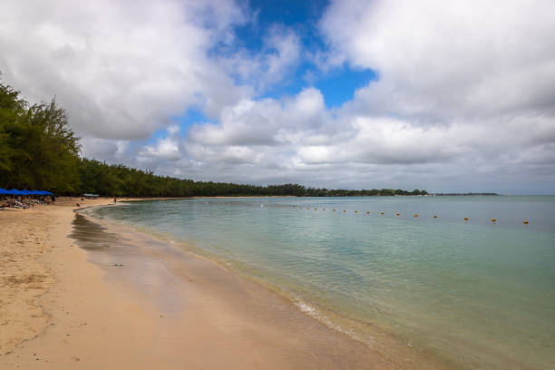 Exposure of the beautiful Mon Choisy Beach, located ion the northwest of the Mauritius Island, a long stretch of soft white sand curves around a turquoise bay fringed by casuarina trees