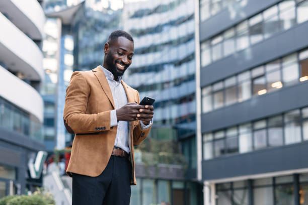 istock Businessman texting on phone among modern buildings 2166212956