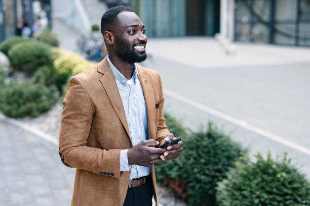istock Smiling man using smartphone outdoors in urban area 2166212962