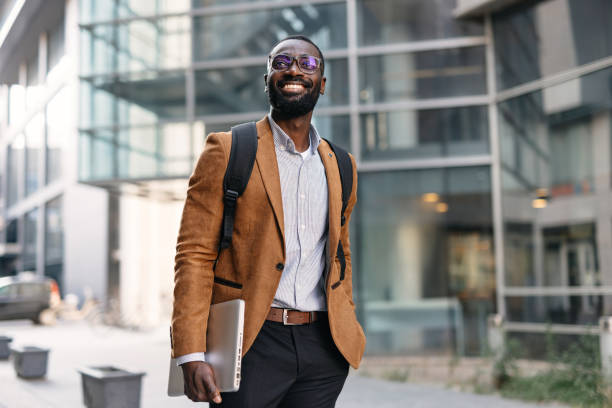 Man walking with laptop in modern urban setting