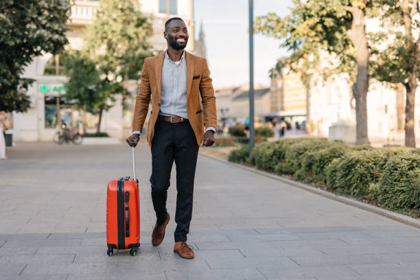 istock Man walking with a red suitcase in urban setting. 2166213937