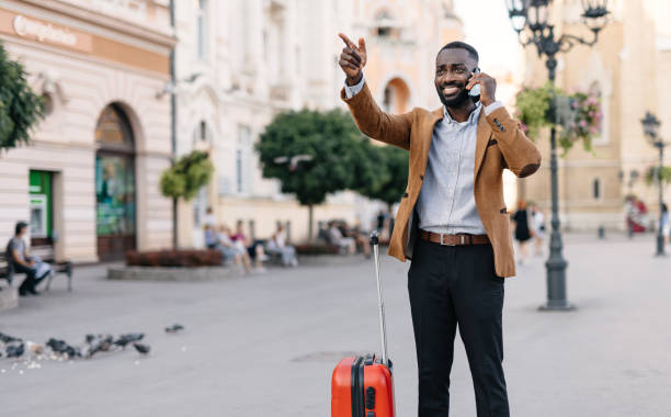 istock Man on phone pointing while holding red suitcase. 2166213959