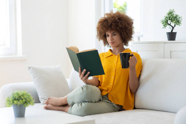 istock Woman relaxing on the sofa and reading a book 2166216035