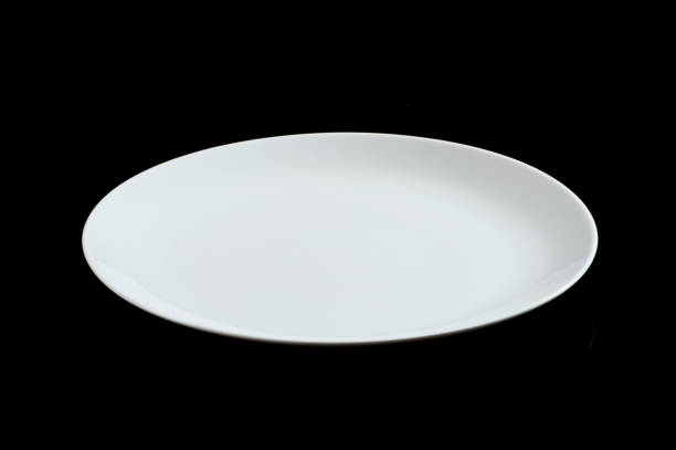 istock Elegant white ceramic plate with a subtle curve, isolated on a black background, ideal for showcasing food presentations or product designs. 2166218956