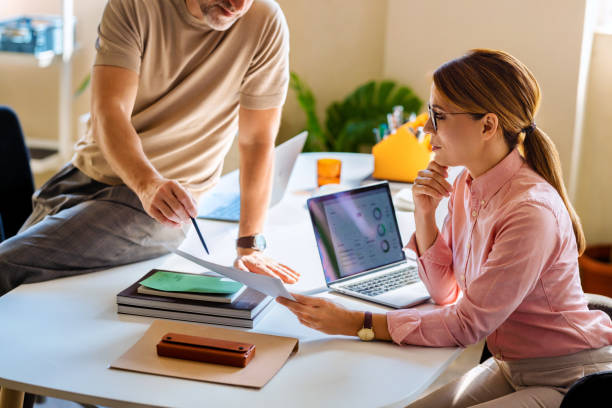 istock Business Meeting Between Colleagues Discussing Data Reports at Office 2166223628