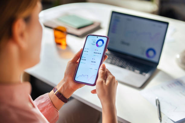 istock Woman Analyzing Financial Data on Smartphone and Laptop 2166223656