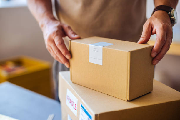 Person Handling Cardboard Boxes for Delivery Service