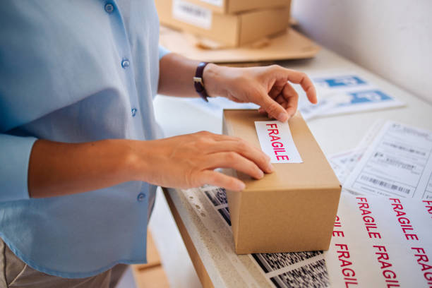 istock Person Labeling Fragile Box for Shipping with Safety Precaution 2166223677