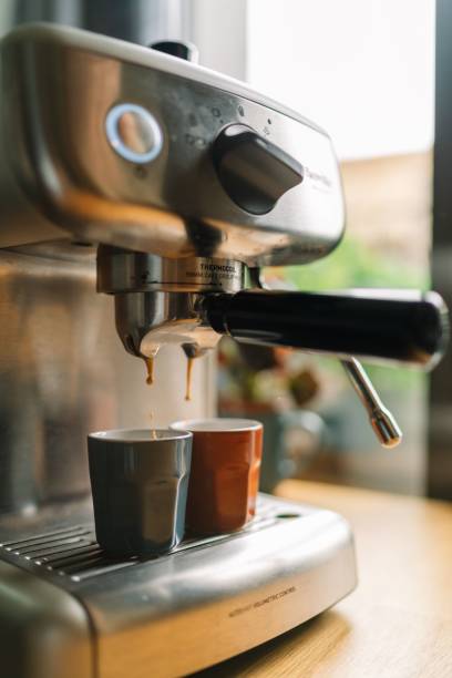 istock Close-up of an espresso machine brewing coffee into two cups in a cozy kitchen setting. 2166226195