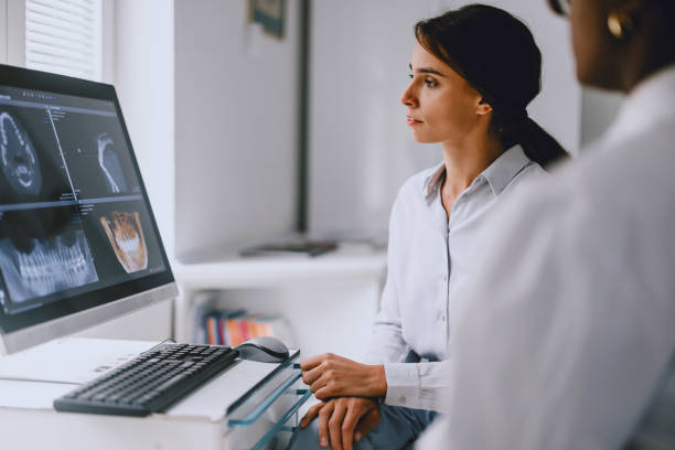 istock Dentist and Patient Reviewing Dental X-Rays on Computer 2166227019
