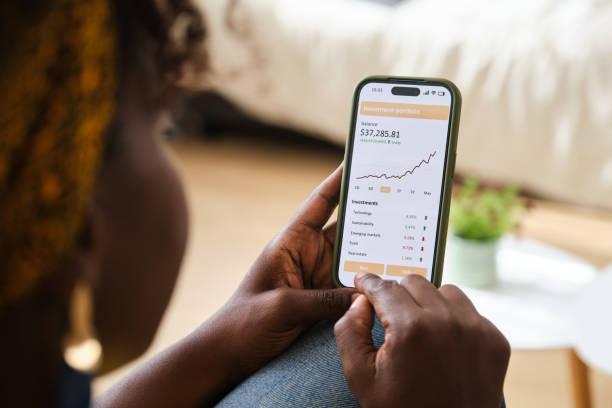 istock Young woman checking her investment portfolio using mobile app 2166227386