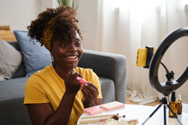 istock Beauty influencer applying lipstick while recording makeup tutorial with smartphone 2166228963