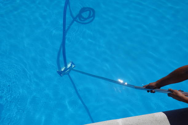 istock man holds pool cleaner to clean private pool or hotel pool 2166230912