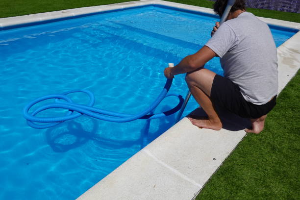 istock man prepares to put in the pool cleaner pipe. prepare pool for summer 2166230962