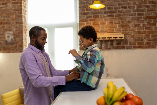 istock Father and son at home getting dressed in the kitchen and looking enjoyed 2166232775