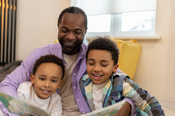istock Happy family reading a book together and looking involved 2166232818