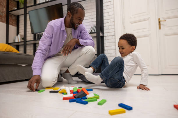 istock African american bearded man looking involved while playing with his son 2166232873