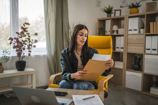 istock Adult woman work from home, open and read a letter from envelope 2166233780